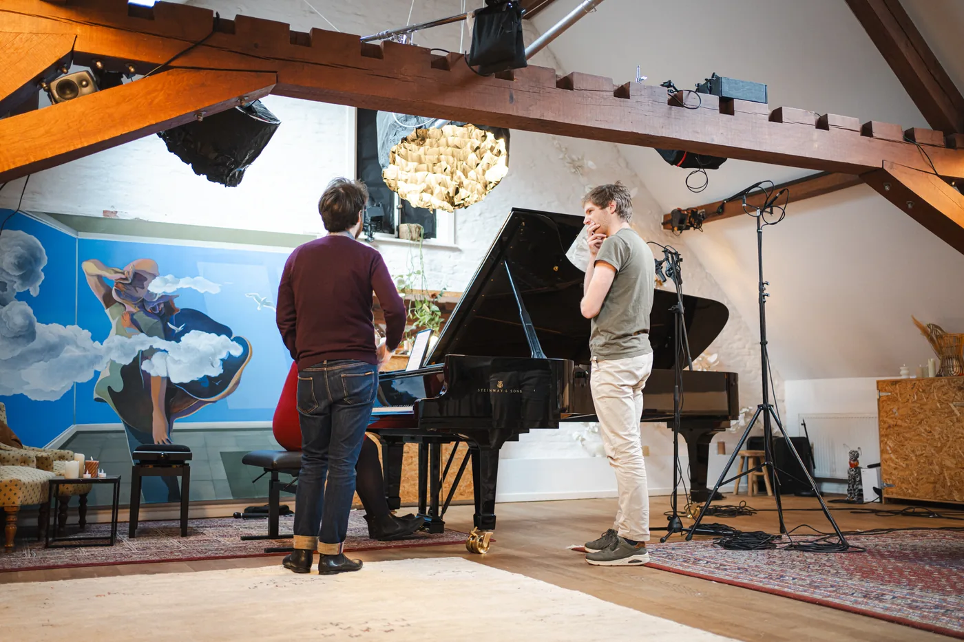 Vue d'ensemble de la salle de concert sous charpente du Studio Jardin Musical à Bruxelles avec piano Steinway et musiciens en discussion